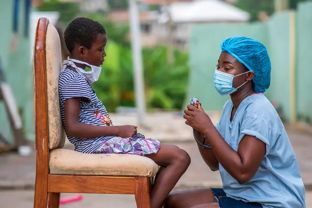 Une médecin examinant un enfant lors d'une campagne de vaccination
