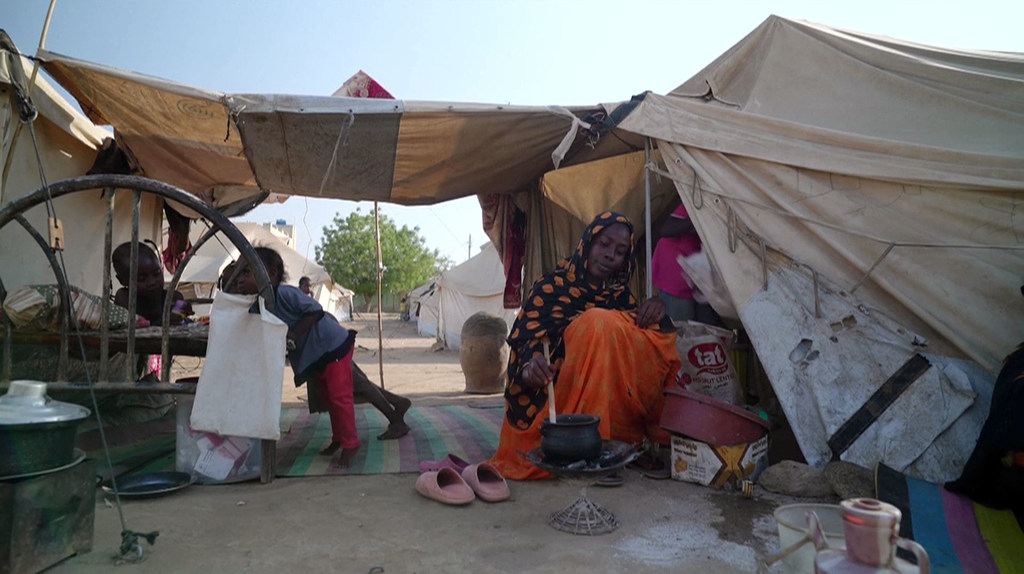 Une femme prépare à manger dans un camp pour personnes déplacées au Soudan.