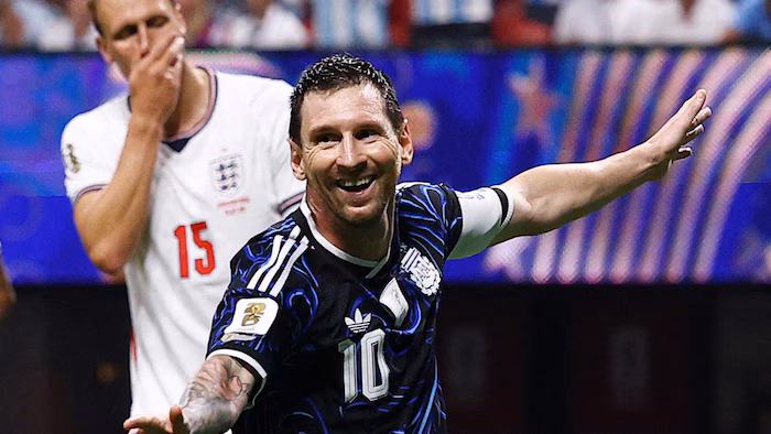 Un joueur de soccer sourit, devant un adversaire à la mine basse.