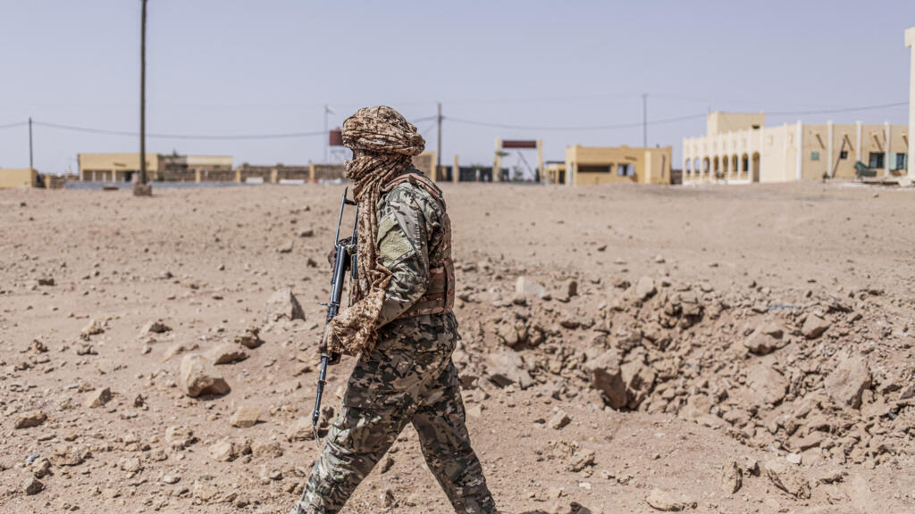 Un militaire inspectant un cratère issu d'un bombardement à Kidal, illustrant l'intensité des tensions sécuritaires au Mali